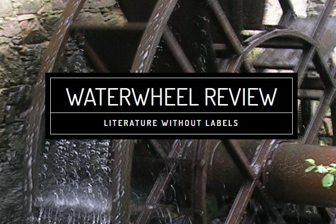 closeup of waterwheel moving water against stone mill