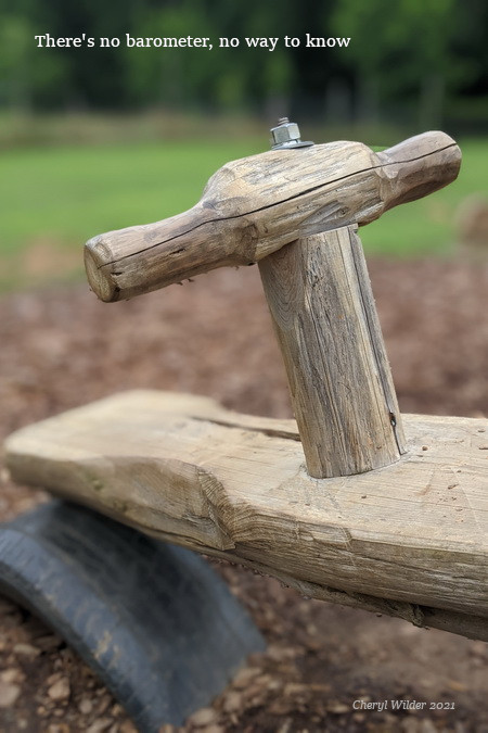 end of hand-carved teeterboard resting on a half-tire support