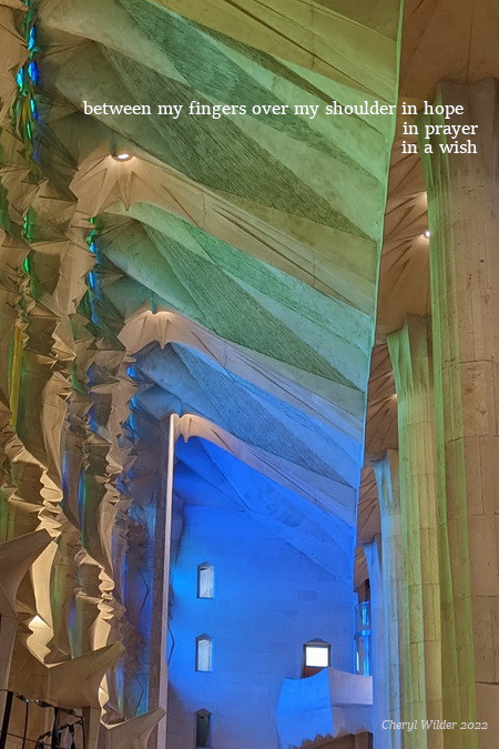 Interior east wall of Sagrada Familia with sunlight reflecting blue and green stained glass windows